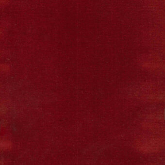 Deep red velvet fabric with a textured surface and directional fibers, displaying a saturated crimson color and uniform pile, with a small label.
